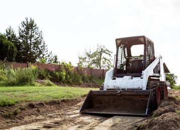 A Skid Steer Loader Clears The Site For Construction. Land Work